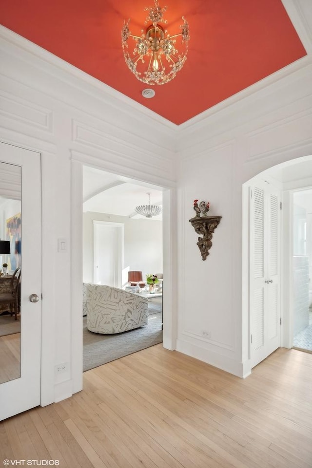 hallway featuring hardwood / wood-style flooring and a notable chandelier