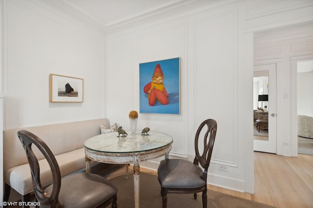 dining space featuring light hardwood / wood-style floors and ornamental molding