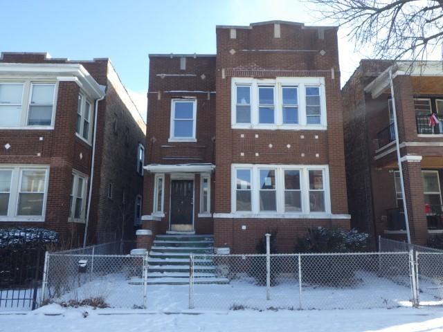 view of front facade featuring brick siding and fence