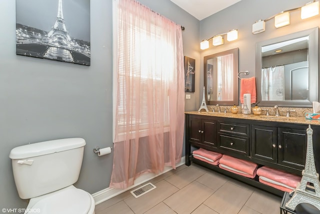 bathroom with tile patterned flooring, vanity, and toilet