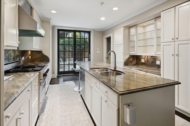 kitchen with white cabinets, a center island with sink, appliances with stainless steel finishes, and sink