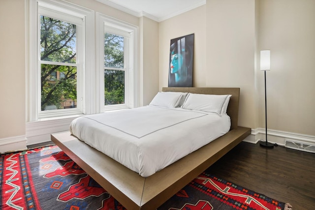 bedroom with dark hardwood / wood-style floors and crown molding