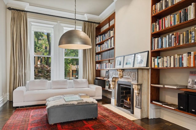 living room featuring hardwood / wood-style flooring, built in features, and crown molding