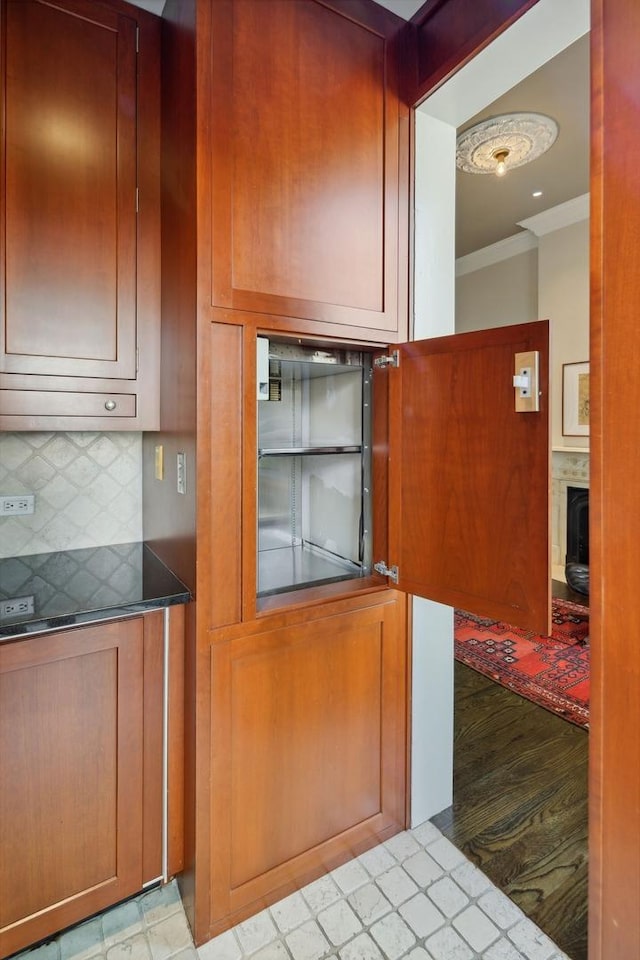 kitchen with a fireplace, decorative backsplash, and crown molding