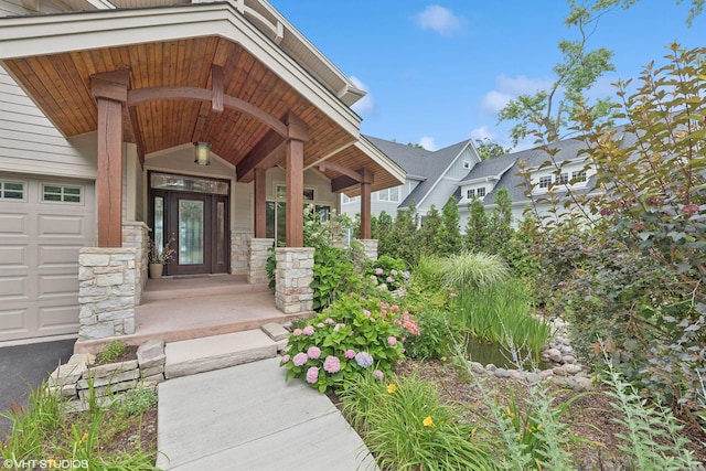 doorway to property with a porch and a garage