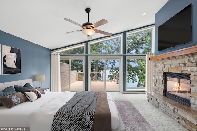 bedroom with a fireplace, vaulted ceiling, access to exterior, light carpet, and ceiling fan