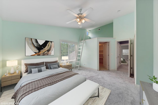 carpeted bedroom featuring ceiling fan and a spacious closet