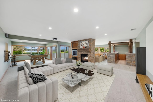 living room featuring billiards, a wealth of natural light, a fireplace, and light carpet