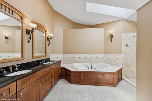 bathroom with vanity, tile walls, a skylight, and a bathtub