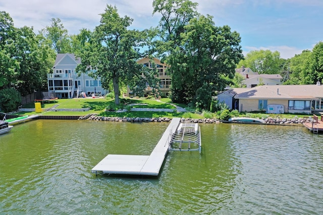 dock area with a lawn and a water view