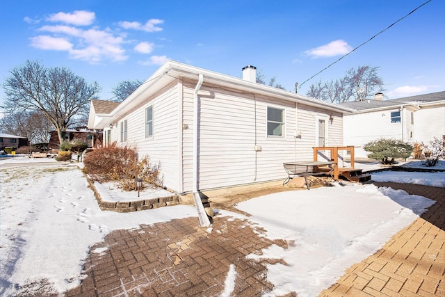 view of snow covered back of property