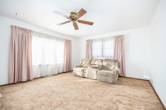 carpeted living room with ceiling fan