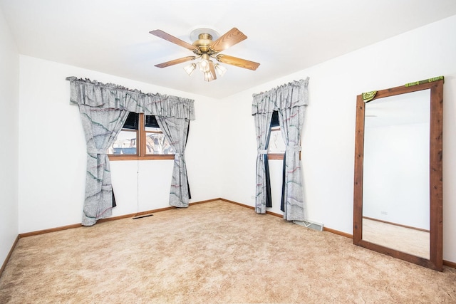 empty room with ceiling fan and carpet floors