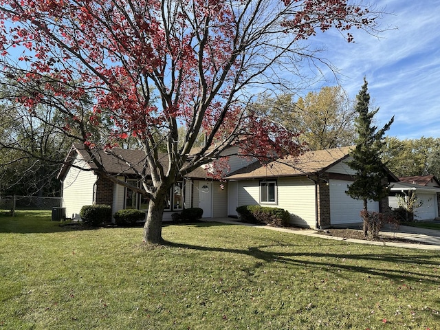 view of front of property featuring a front yard, a garage, and central air condition unit