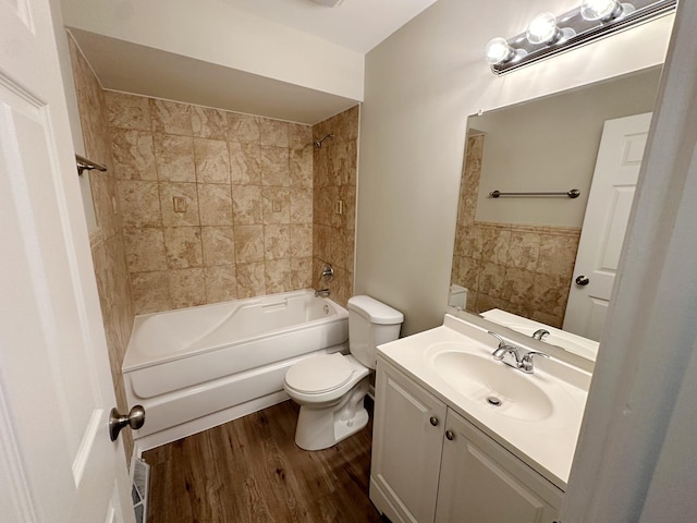 full bathroom with hardwood / wood-style floors, vanity, toilet, and tiled shower / bath combo