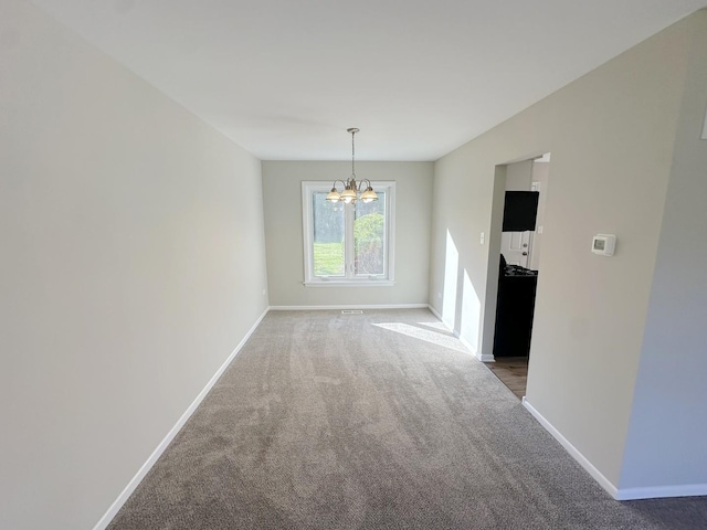 unfurnished dining area featuring carpet and a chandelier