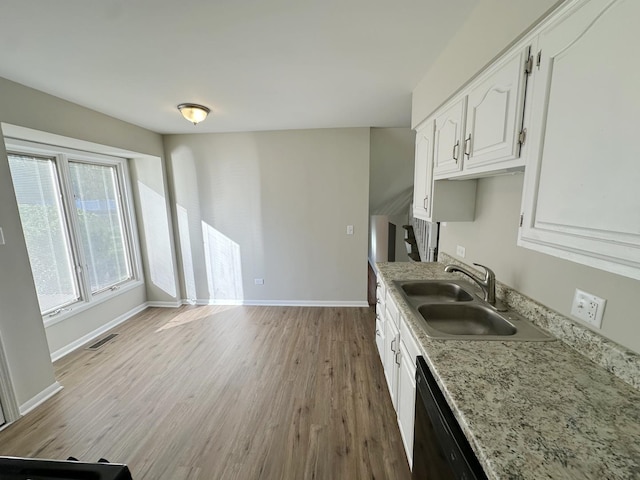 kitchen featuring dishwasher, sink, light wood-type flooring, light stone counters, and white cabinetry