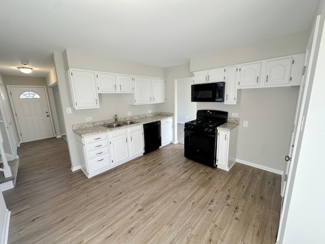 kitchen featuring white cabinetry, sink, black appliances, and light hardwood / wood-style flooring