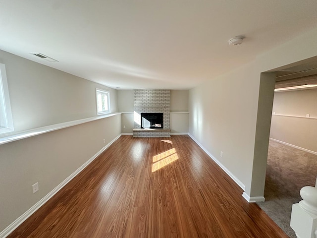 unfurnished living room with a fireplace and wood-type flooring