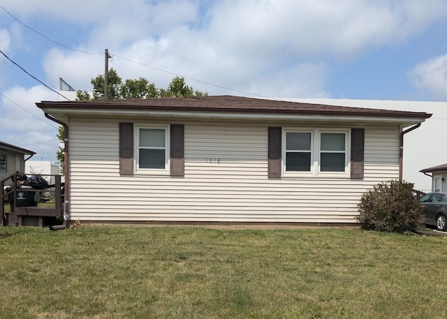 view of side of home with a yard