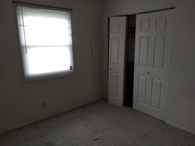 unfurnished bedroom featuring light colored carpet and a closet