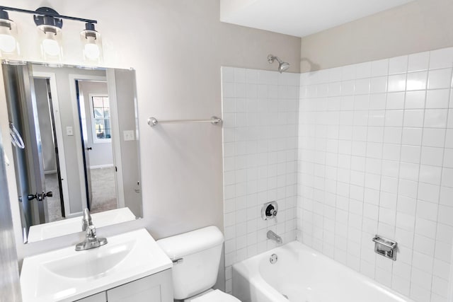 full bathroom with vanity, tiled shower / bath combo, and toilet