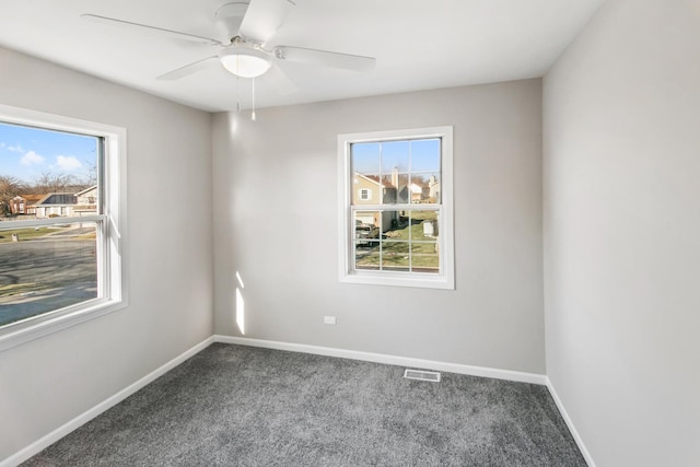 carpeted spare room with ceiling fan and a healthy amount of sunlight