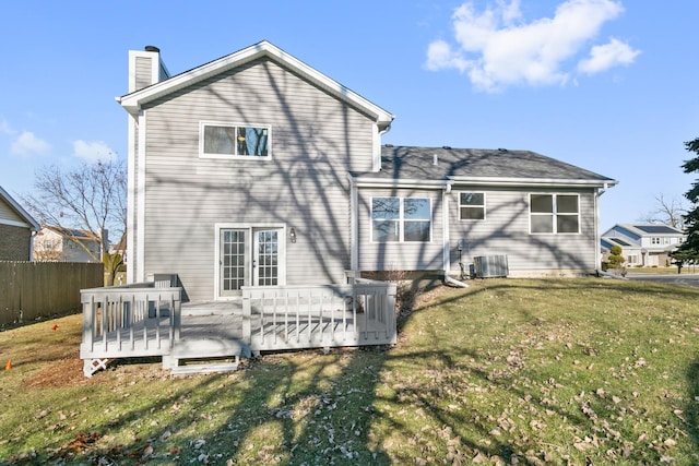 back of property with a lawn, a wooden deck, and central AC