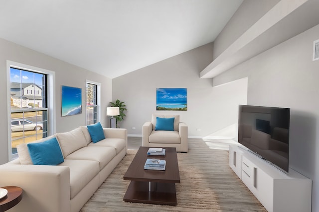 living room featuring light wood-type flooring and vaulted ceiling