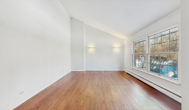 unfurnished room with baseboard heating, vaulted ceiling, and hardwood / wood-style floors