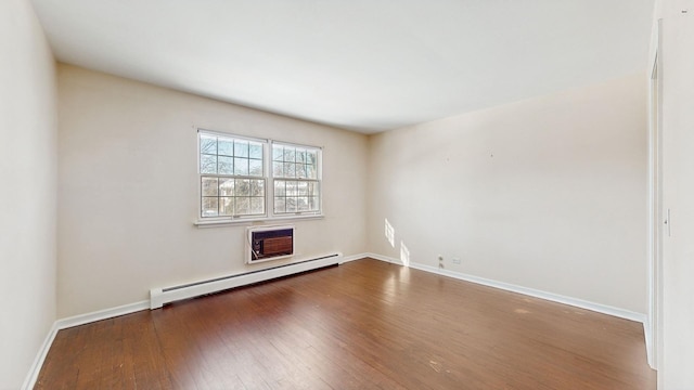 spare room with baseboard heating, dark wood-type flooring, and a wall mounted AC