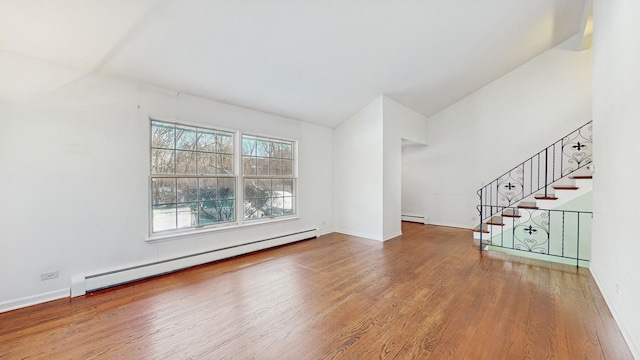 unfurnished living room with a baseboard radiator, hardwood / wood-style floors, and vaulted ceiling