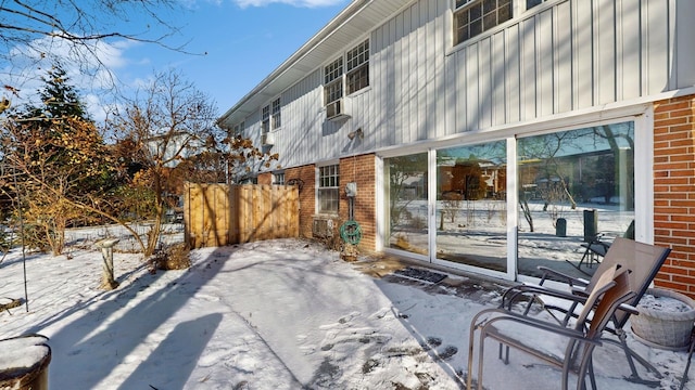 view of snow covered back of property