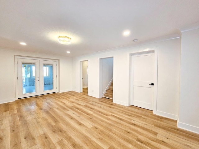 empty room with light hardwood / wood-style flooring, crown molding, and french doors