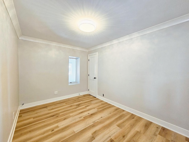 spare room featuring crown molding and light wood-type flooring