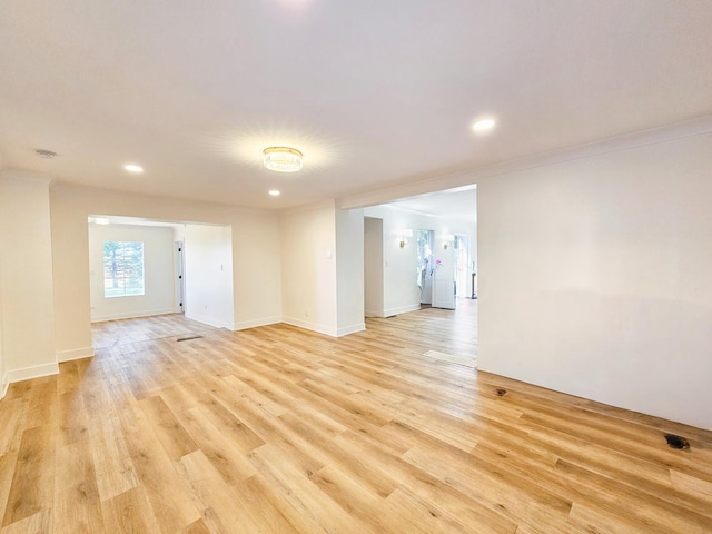 spare room with ornamental molding and light hardwood / wood-style floors