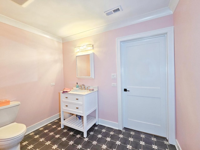 bathroom featuring toilet, crown molding, and vanity