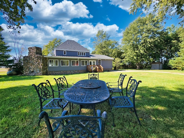 back of property with a garage, an outbuilding, and a yard