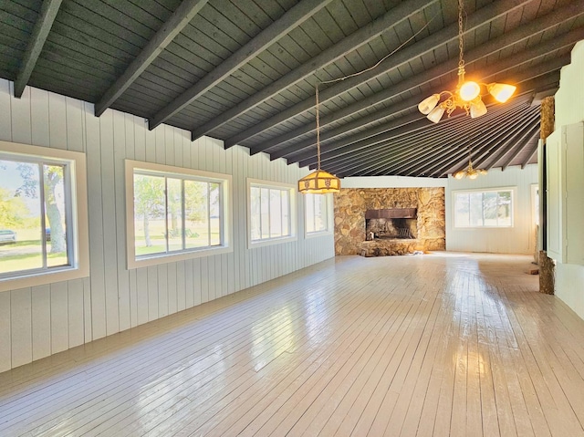 unfurnished living room with a fireplace, hardwood / wood-style floors, lofted ceiling with beams, a chandelier, and wooden ceiling