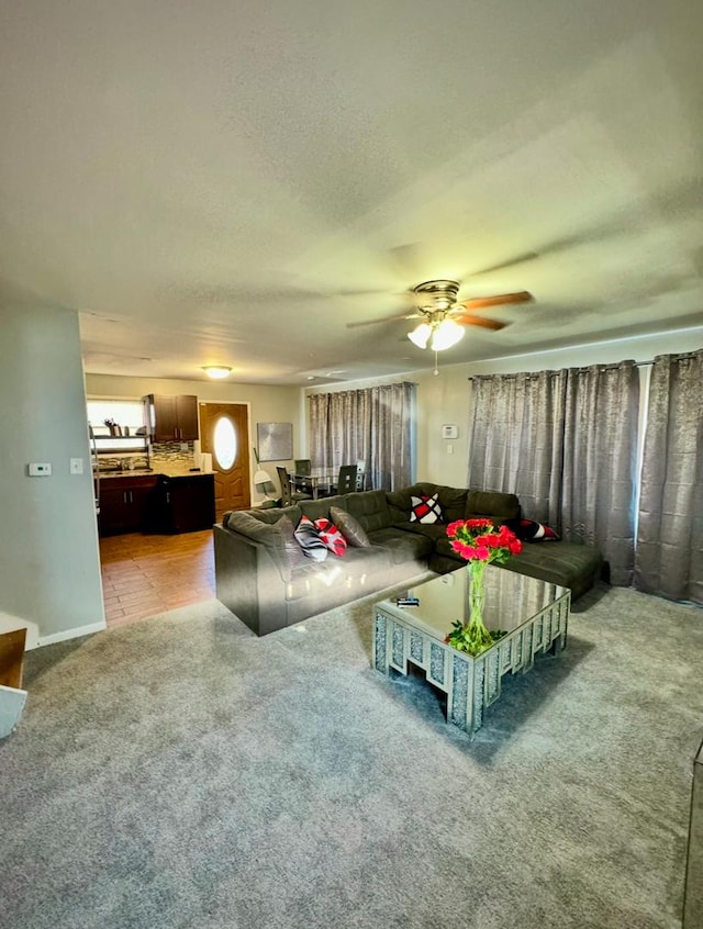 carpeted living room featuring ceiling fan