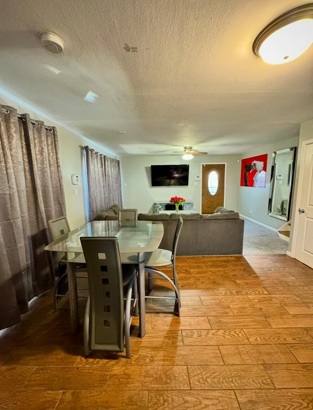 dining room featuring a textured ceiling, ceiling fan, and hardwood / wood-style floors