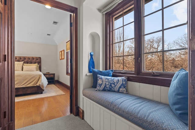 bedroom with wood-type flooring and vaulted ceiling