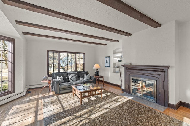 living room featuring wood-type flooring, a baseboard heating unit, beam ceiling, and a textured ceiling