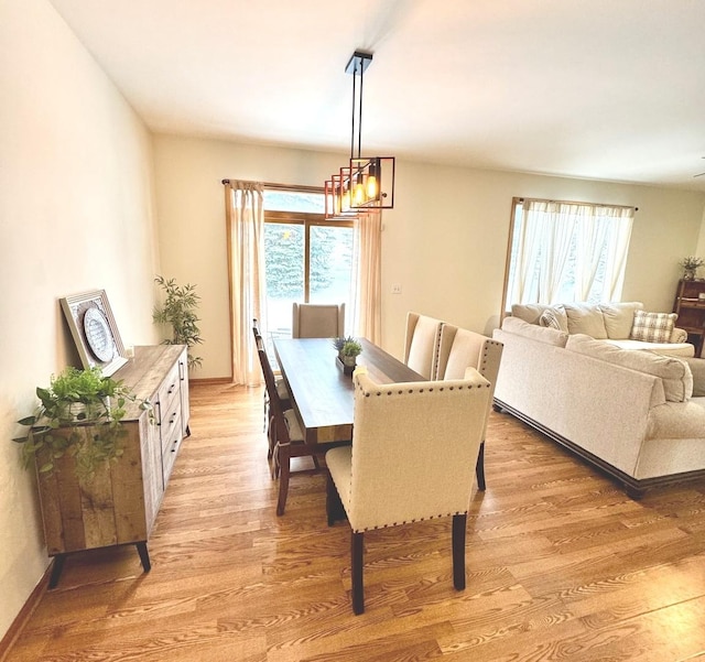 dining space with light hardwood / wood-style floors and a chandelier