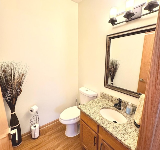 bathroom with vanity, toilet, and wood-type flooring