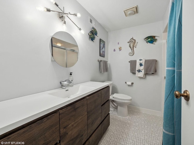 bathroom with toilet, vanity, tile patterned floors, and a shower with shower door