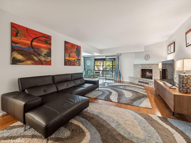 living room with light hardwood / wood-style flooring and a brick fireplace