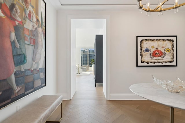 hallway with an inviting chandelier, parquet floors, and ornamental molding