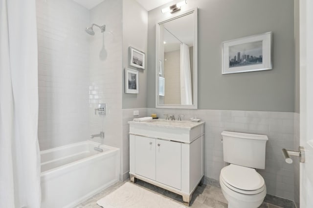 full bathroom with vanity, toilet, shower / bathtub combination with curtain, and tile walls