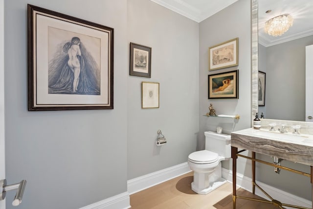 bathroom with crown molding, hardwood / wood-style floors, an inviting chandelier, and toilet